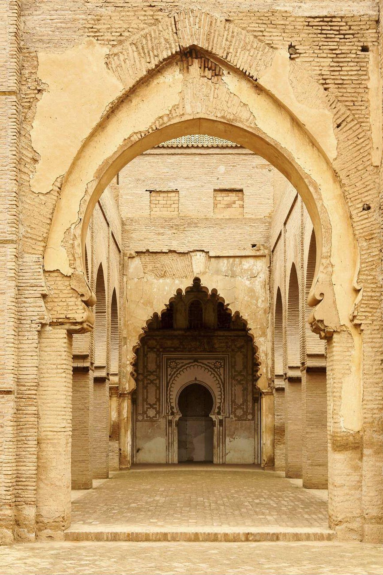 Tinmel Mosque, located in the village of Tinmel in the High Atlas Mountains, approximately 100 km south of Marrakech, Morocco, is one of the most important historical monuments reflecting the beauty of Islamic architecture during the Almohad era. Commissioned by the first Almohad caliph, Abd al-Mu’min ibn Ali al-Kumi, in 1153 AD (548 AH), the mosque was built to commemorate the founder of the Almohad movement, Muhyiddin Ibn Tumart, who was born in this region. The mosque also houses the tomb of Ibn Tumart, making it a significant spiritual and historical site. Tinmel Mosque features a rectangular layout measuring 48.10 meters in length and 43.60 meters in width, surrounded by high walls topped with crenellations. Its prayer hall consists of nine aisles oriented toward the qibla, with a “T”-shaped geometric design characteristic of Almohad architecture. Originally three domes were evenly distributed along the qibla aisle, but only one dome in the southwest corner remains today. The mosque symbolizes the intellectual and political revival of the Almohad state, which extended from Morocco to Andalusia and North Africa. Despite partial destruction caused by the Al Haouz earthquake in September 2023, Tinmel Mosque remains a must-visit heritage site in Morocco, showcasing both historical and architectural significance. It is accessible via National Route 9 from Marrakech, and visiting with a professional tour guide is recommended to fully appreciate its history and design.