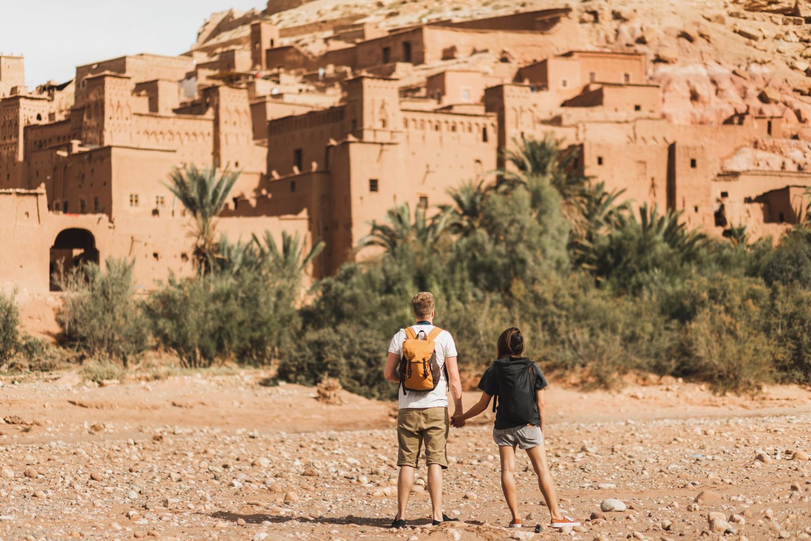 Couple of backpacker travelers on background Ait Ben Haddou ksar in Ouarzazate. Welcome to Morocco. Travel concept. Popular landmark.